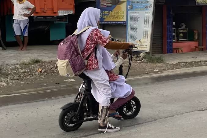 Ilustrasi: Anak sekolah mengendarai sepeda motor listrik