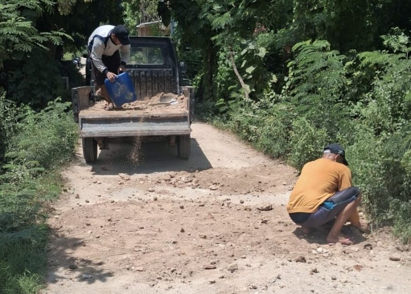Foto: Di tengah minimnya respons pemerintah, warga Banbaru Giliraja bergotong royong memperbaiki akses jalan utama yang sudah lama rusak.
