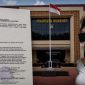 Foto: Oknum LC berinisial S yang wajahnya telah disamarkan, bersama Surat Tanda Penerimaan Laporan (STPL) di Polres Sumenep terkait dugaan pencemaran nama baik melalui media sosial