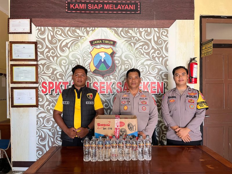foto: Petugas Polsek Sapeken menunjukkan barang bukti 10 botol minuman keras jenis Arak Bali Karangasem yang diamankan dari sebuah rumah di Dusun Karangkongo, Desa Sapeken, Kecamatan Sapeken.
