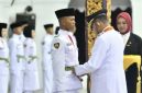 Foto: Bupati Sumenep Achmad Fauzi Wongsojudo memasangkan kendit kepada perwakilan Paskibraka 2026 saat prosesi pengukuhan di Pendopo Agung Keraton Sumenep