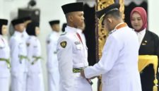 Foto: Bupati Sumenep Achmad Fauzi Wongsojudo memasangkan kendit kepada perwakilan Paskibraka 2026 saat prosesi pengukuhan di Pendopo Agung Keraton Sumenep