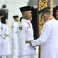 Foto: Bupati Sumenep Achmad Fauzi Wongsojudo memasangkan kendit kepada perwakilan Paskibraka 2026 saat prosesi pengukuhan di Pendopo Agung Keraton Sumenep