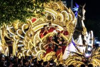 Penampilan Tong-Tong Sumenep dalam parade budaya, menampilkan kendaraan hias bernuansa emas, iringan musik tradisional, serta ornamen khas Madura di tengah kerumunan masyarakat.