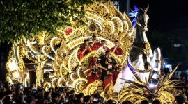 Penampilan Tong-Tong Sumenep dalam parade budaya, menampilkan kendaraan hias bernuansa emas, iringan musik tradisional, serta ornamen khas Madura di tengah kerumunan masyarakat.